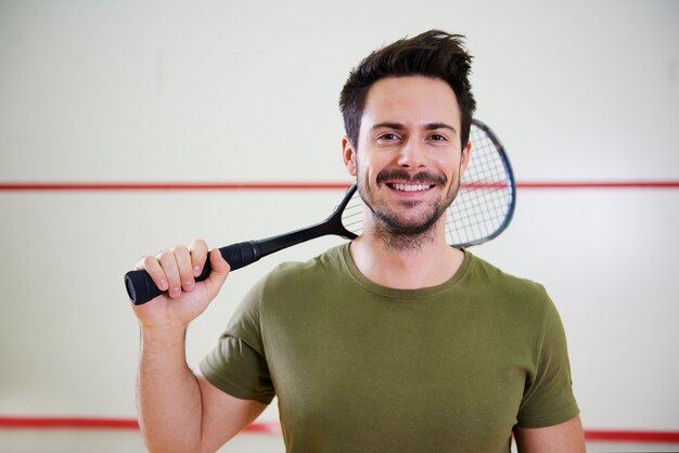 Vista frontal del hombre con raqueta antes del juego de squash