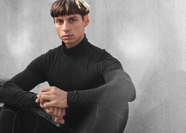 Foto gratuita vista frontal del hombre en ropa deportiva posando en las escaleras al aire libre