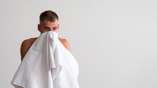 Foto gratuita vista frontal del hombre secándose la cara con una toalla después del lavado