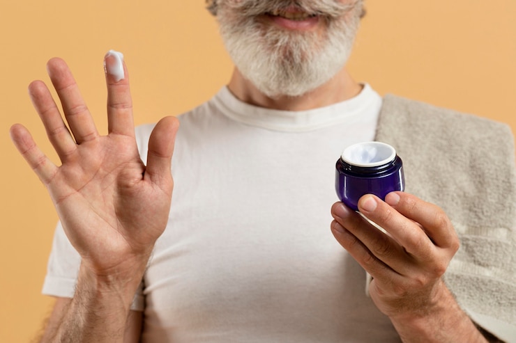 Foto gratuito vista frontal del hombre senior con barba con crema hidratante