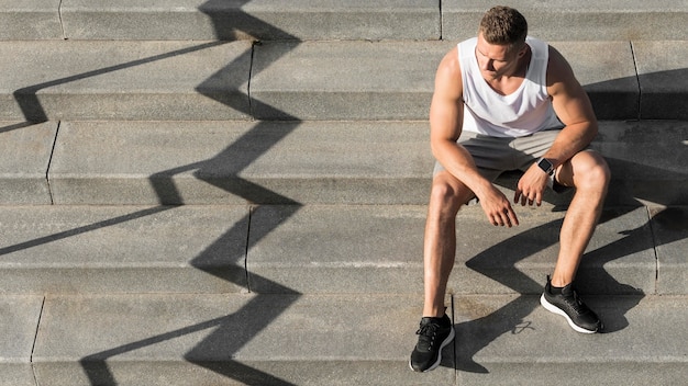 Foto gratuita vista frontal hombre sentado en las escaleras con espacio de copia