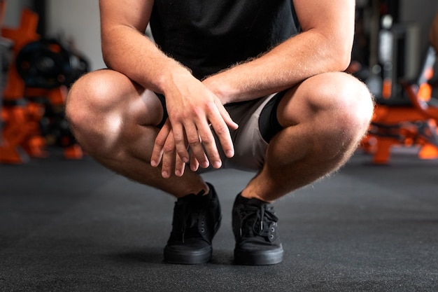 Vista frontal hombre sentado en el gimnasio