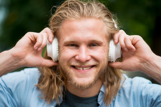 Vista frontal del hombre sonriente con auriculares