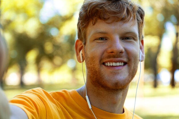 Vista frontal hombre sonriente con auriculares