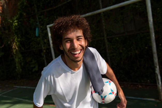 Vista frontal hombre sonriente en el campo de fútbol