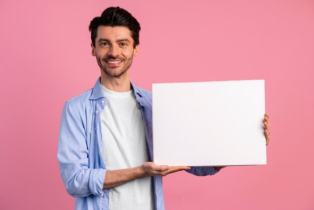 Vista frontal del hombre sonriente con cartel en blanco