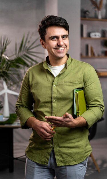 Vista frontal del hombre sonriente junto a un diseño de proyecto de energía eólica ecológico