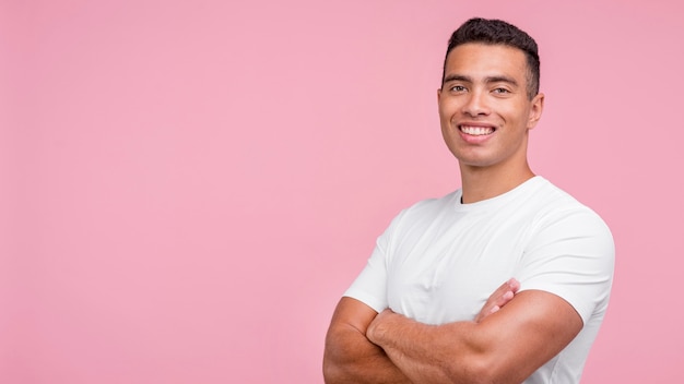 Vista frontal del hombre sonriente posando con los brazos cruzados.