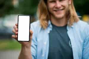 Foto gratuita vista frontal del hombre sonriente con smartphone