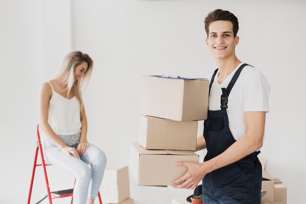 Vista frontal hombre sonriente sosteniendo cajas