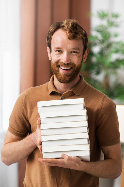 Vista frontal hombre sonriente sosteniendo cajas