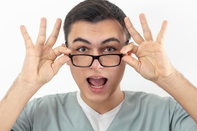 Vista frontal del hombre sonriente sosteniendo sus gafas en la cara