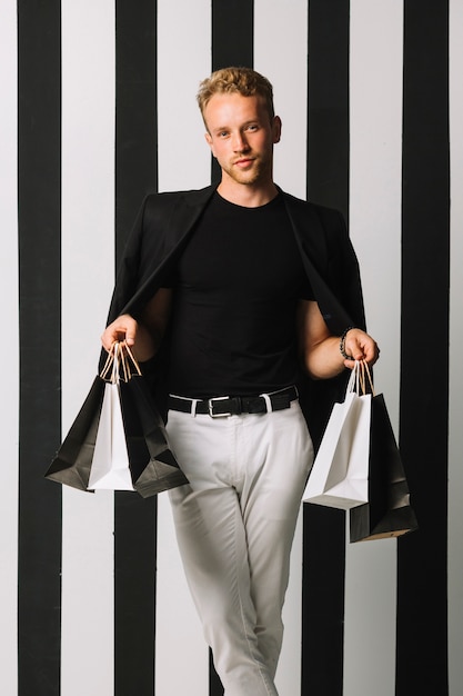 Foto gratuita vista frontal hombre sosteniendo bolsas de compras