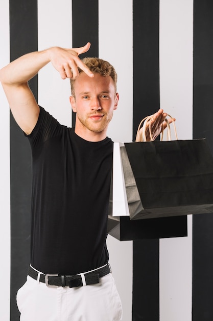 Foto gratuita vista frontal hombre sosteniendo bolsas de compras