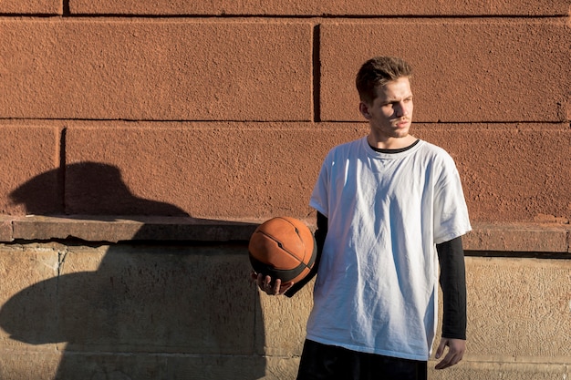 Vista frontal hombre sosteniendo una pelota de baloncesto