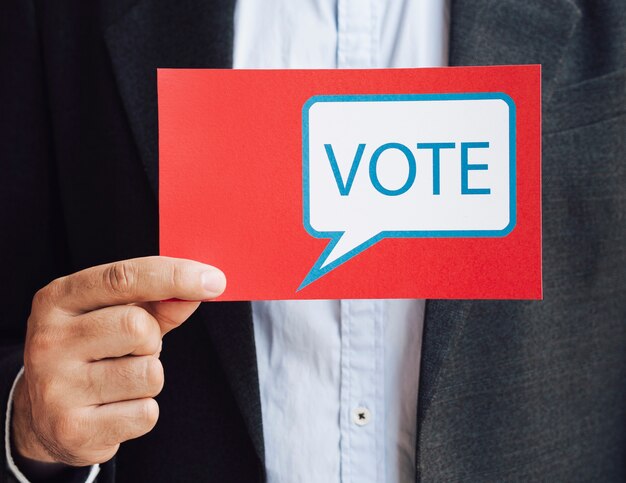 Vista frontal hombre sosteniendo una tarjeta de burbujas de discurso de votación