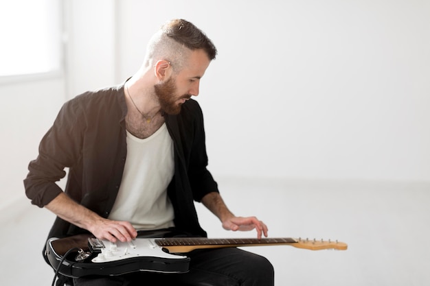 Vista frontal del hombre tocando la guitarra eléctrica