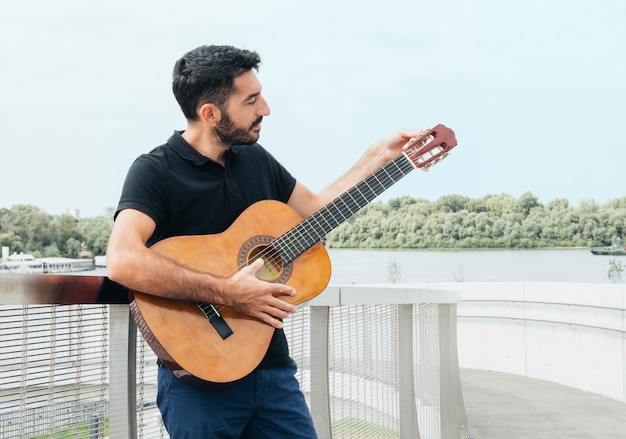 Vista frontal del hombre tocando la guitarra