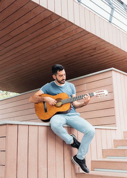 Vista frontal del hombre tocando la guitarra