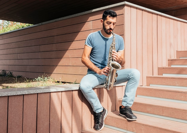 Foto gratuita vista frontal del hombre tocando el saxofón concepto