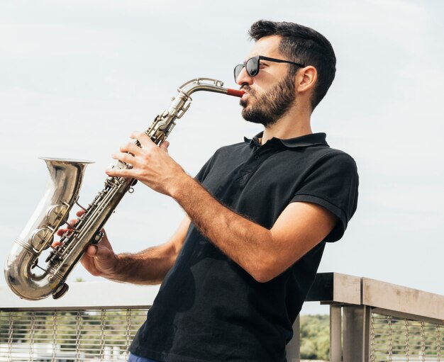Vista frontal del hombre tocando el saxofón