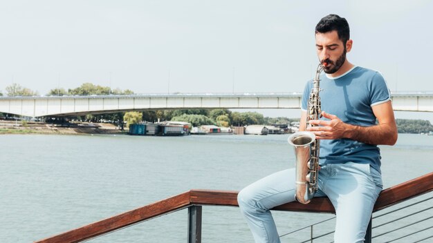 Vista frontal del hombre tocando el saxofón