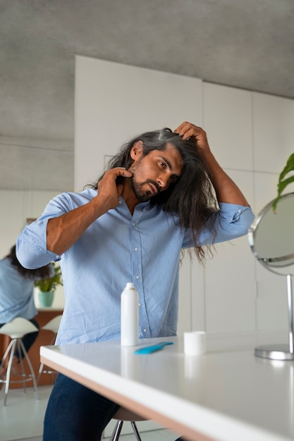 Foto gratuita vista frontal hombre usando champú seco en casa