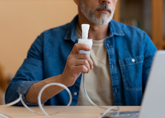 Vista frontal hombre usando nebulizador