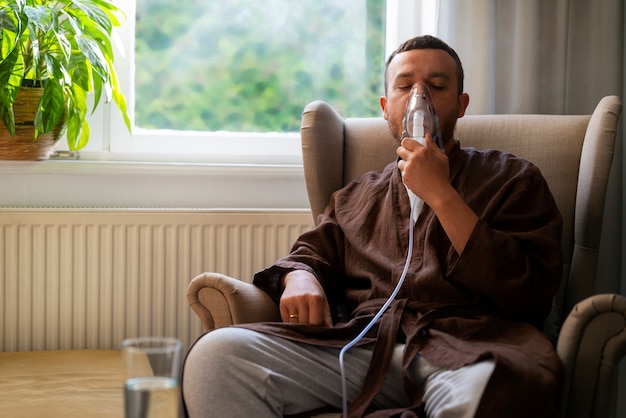 Vista frontal hombre usando un nebulizador