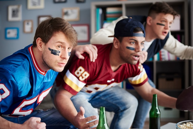 Vista frontal de hombres emocionados viendo juegos deportivos