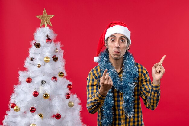 Vista frontal de los hombres jóvenes alrededor de la atmósfera de año nuevo en el color de la pared roja vacaciones navidad