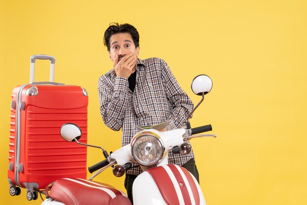 Vista frontal de los hombres jóvenes alrededor de la bicicleta observando el mapa sobre fondo amarillo viaje por carretera viaje de vacaciones en motocicleta