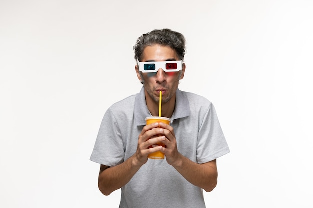 Vista frontal de los hombres jóvenes bebiendo refrescos y con gafas de sol d en el escritorio blanco