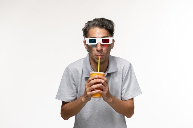 Vista frontal de los hombres jóvenes bebiendo refrescos y con gafas de sol d en el escritorio blanco