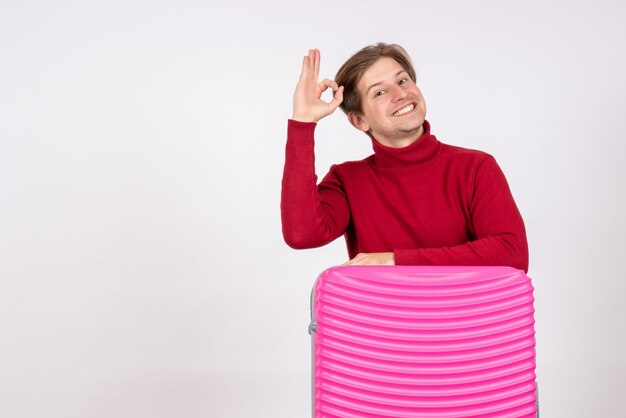 Vista frontal de los hombres jóvenes con bolsa rosa sonriendo sobre fondo blanco.