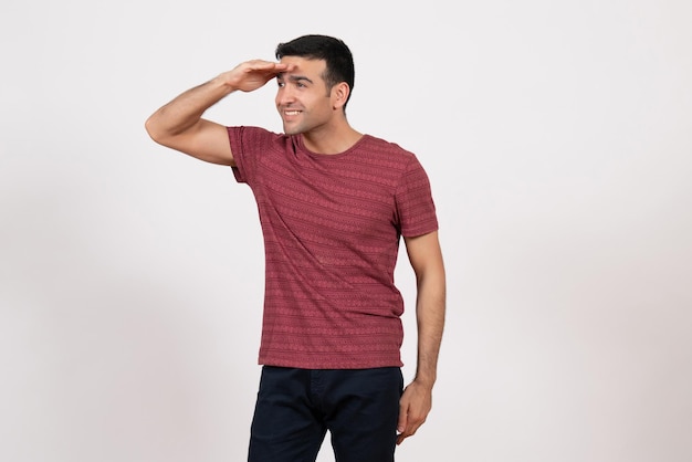 Vista frontal de los hombres jóvenes en camiseta de color rojo oscuro sonriendo sobre fondo blanco.