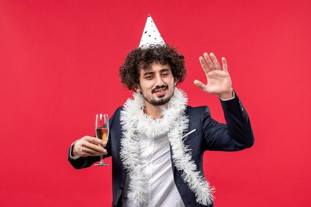 Vista frontal de los hombres jóvenes celebrando otro año en la pared roja humana Navidad vacaciones