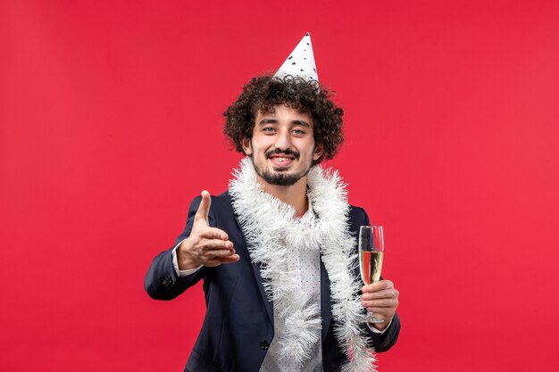 Vista frontal de los hombres jóvenes celebrando otro año en la pared roja Navidad vacaciones humanas