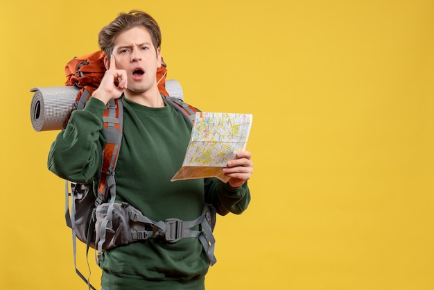 Vista frontal de los hombres jóvenes preparándose para el senderismo observando el mapa