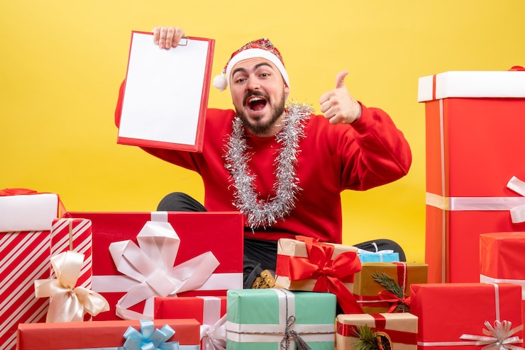 Foto gratuito vista frontal de los hombres jóvenes sentados alrededor de regalos con una nota sobre fondo amarillo