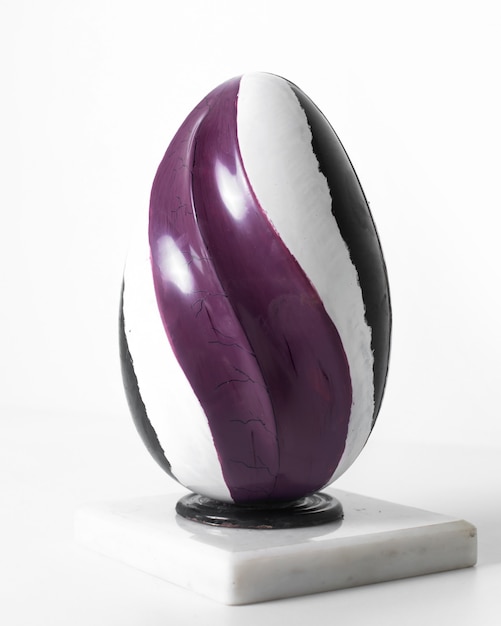 Vista frontal de huevo de color púrpura blanco y negro forrado en el piso blanco