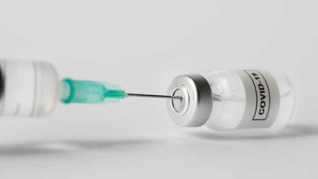Vista frontal jeringa y frasco de vacuna