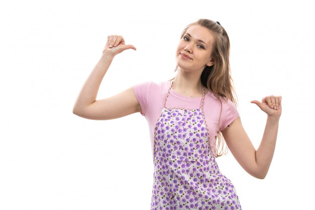 Una vista frontal joven ama de casa hermosa en camisa rosa colorida capa sonriendo posando