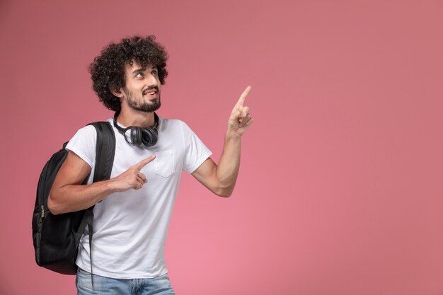 Vista frontal joven apuntando hacia arriba con su bolso