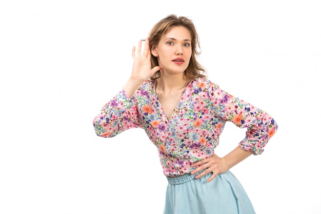 Foto gratuita una vista frontal joven y atractiva dama en camisa colorida flor diseñada y falda azul posando en el blanco