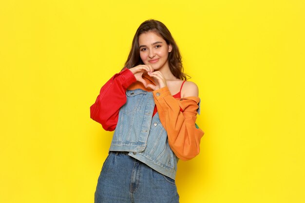 Una vista frontal joven y bella dama en abrigo de camisa roja y jeans azul con expresión sonriente