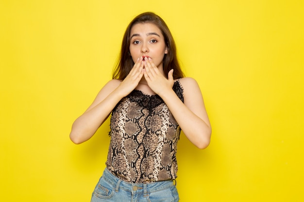 Una vista frontal joven bella dama en blusa marrón y jeans azul sorprendió