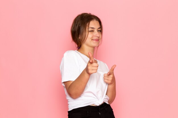 Una vista frontal joven y bella mujer en camisa blanca divertida posando