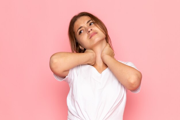 Una vista frontal joven y bella mujer en camisa blanca con dolor de cuello