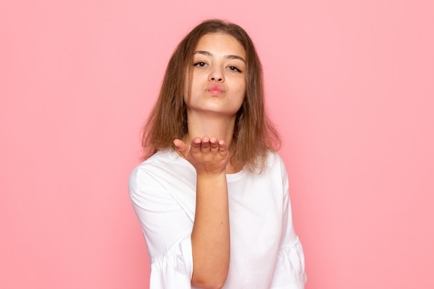 Una vista frontal joven y bella mujer en camisa blanca enviando besos aéreos